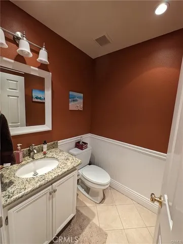 a bathroom with a granite countertop sink a toilet and mirror