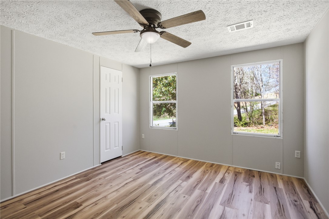 202 Greenbriar Drive Seneca, SC 29678 - Photo 33 of 37 This spacious bedroom features warm wood flooring and ample natural light from two large windows.
