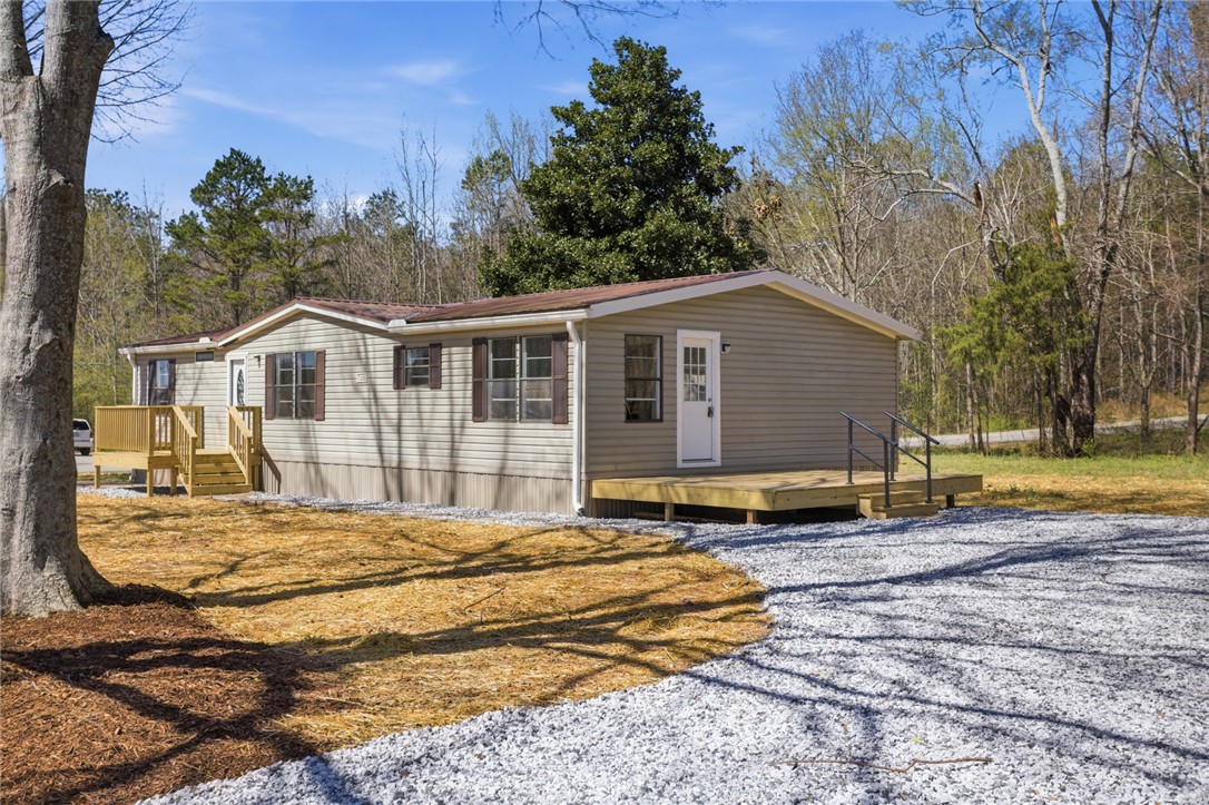 202 Greenbriar Drive Seneca, SC 29678 - Photo 4 of 37 This charming residence is nestled among mature trees, offering a tranquil retreat with a gravel driveway.