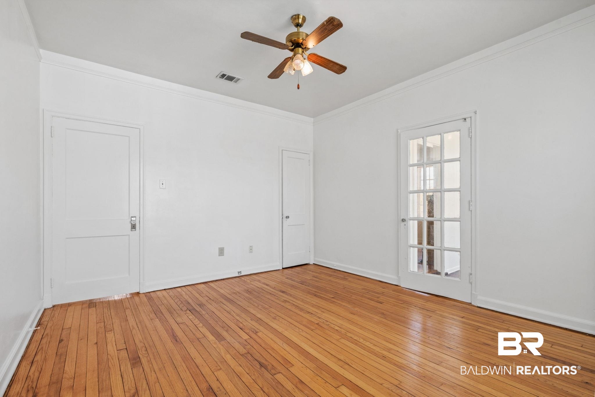 1707 Church Street Mobile, AL 36604 - Photo 30 of 43 Empty room featuring visible vents, light wood-style floors, crown molding, and a ceiling fan