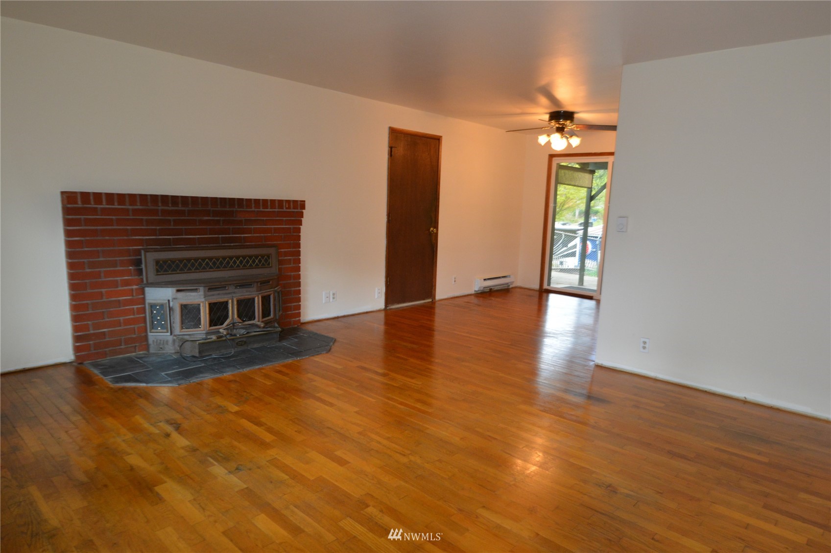 13243 Lake Kathleen Road Southeast Renton, WA 98059 - Photo 4 of 16 a view of empty room with wooden floor and fireplace