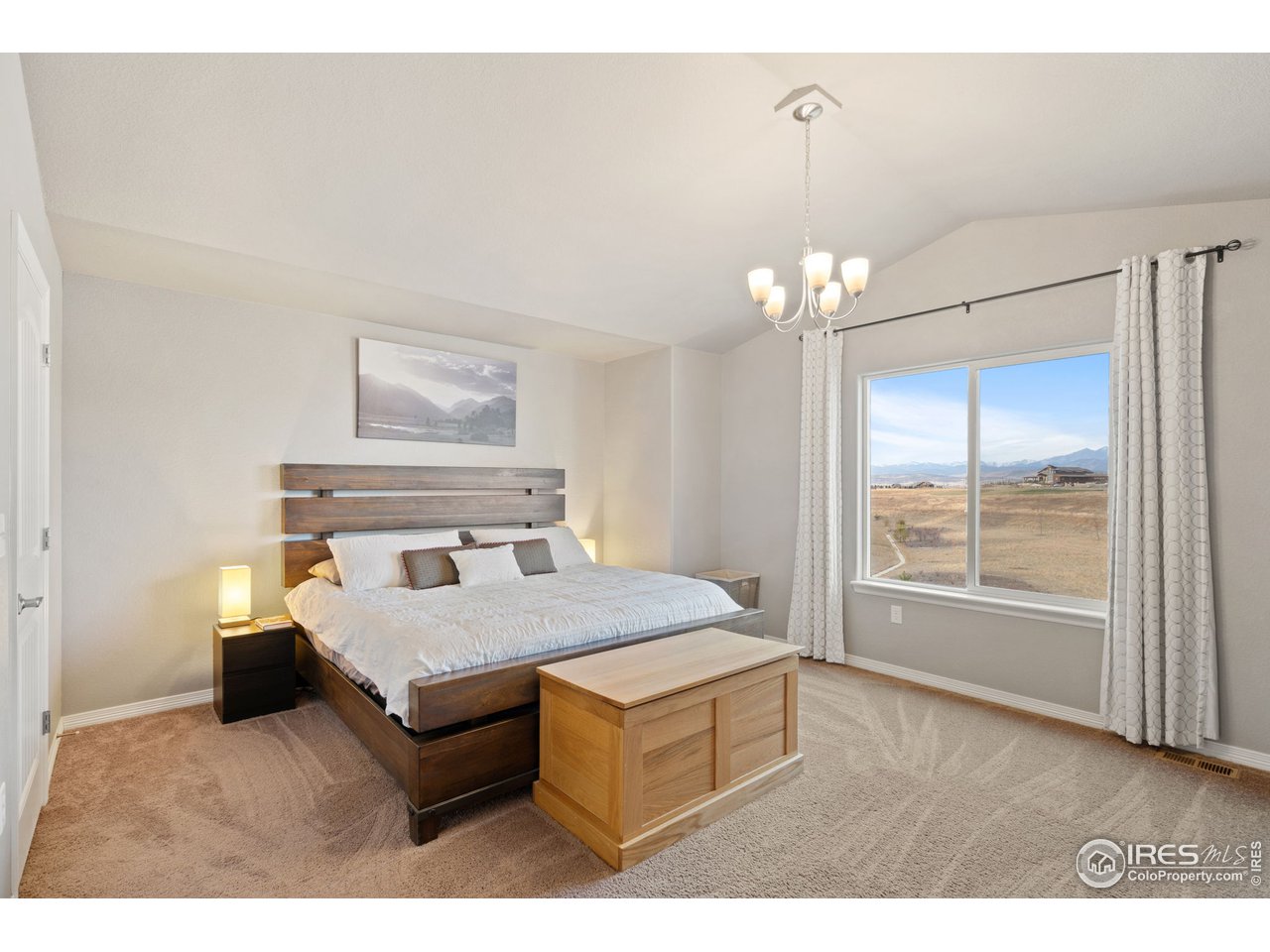 2499 Likens Drive Berthoud, CO 80513 - Photo 14 of 33 a bedroom with a large bed and a chandelier