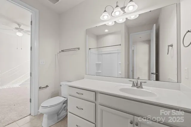 a bathroom with a granite countertop sink a toilet and a mirror
