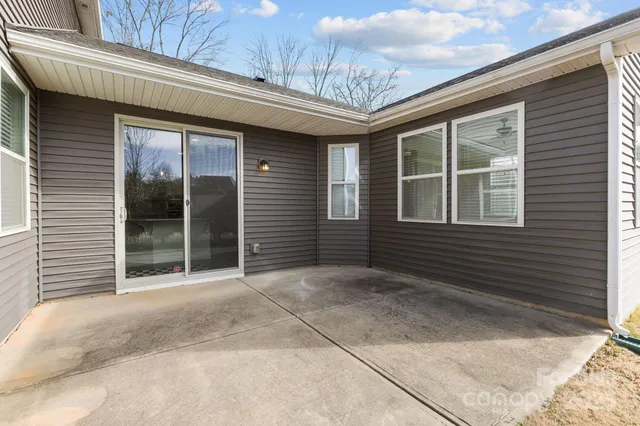 a view of a house with a large window and wooden fence