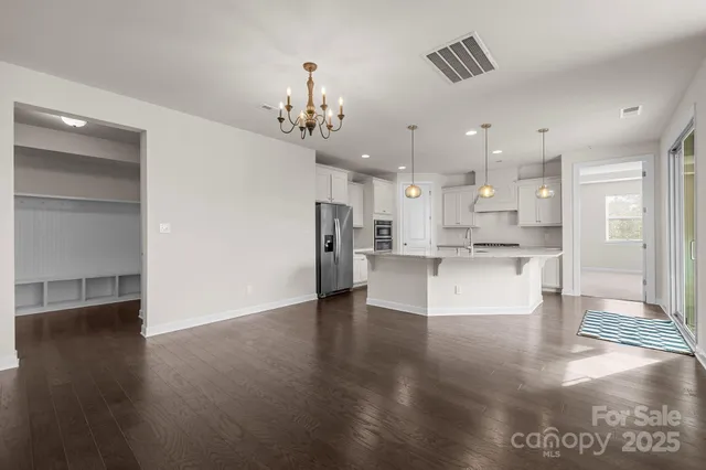 a view of kitchen with kitchen island stainless steel appliances cabinets and wooden floor
