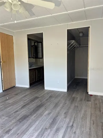 an empty room with wooden floor and closet