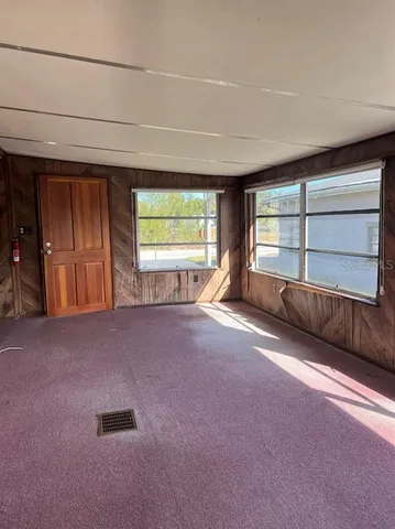 an empty room with a fireplace and windows