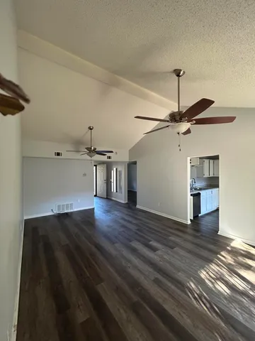 a view of a livingroom with wooden floor and a ceiling fan