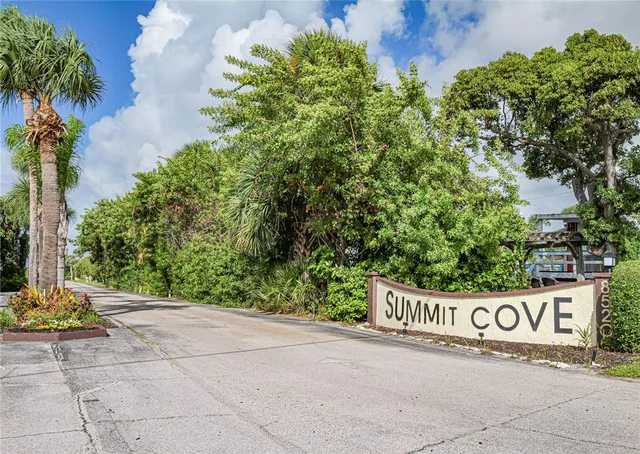 a view of sign board with yard and trees