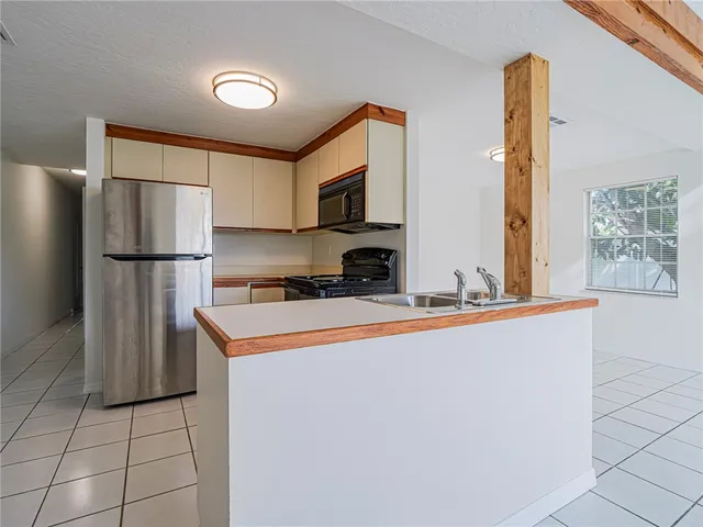 a kitchen with stainless steel appliances granite countertop a refrigerator a stove a sink and a more cabinets