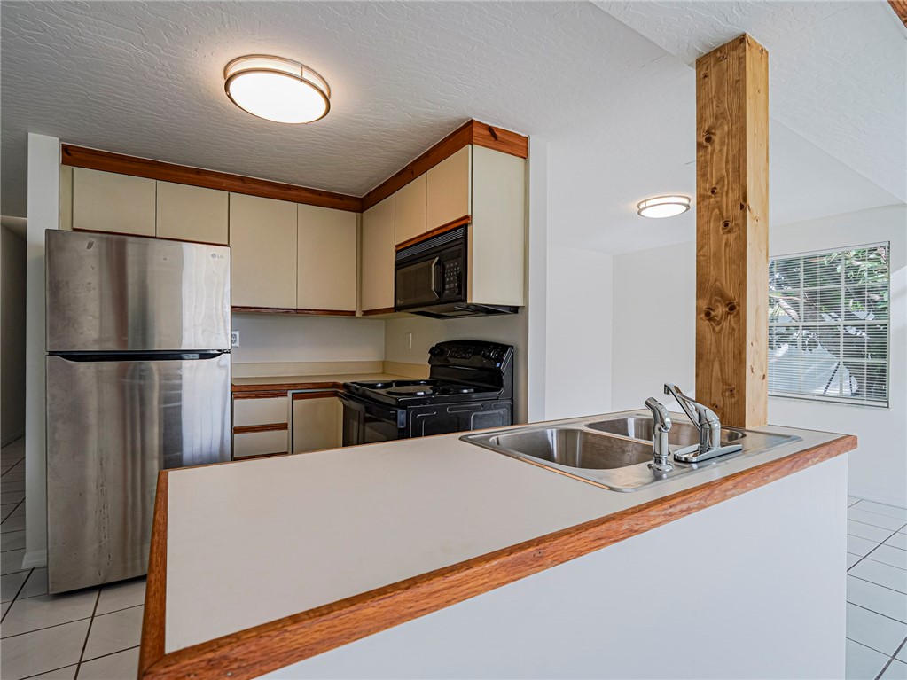 8520 Highway 1, Unit H12 Sebastian, FL 32976 - Photo 17 of 35 a kitchen with stainless steel appliances a refrigerator sink and microwave