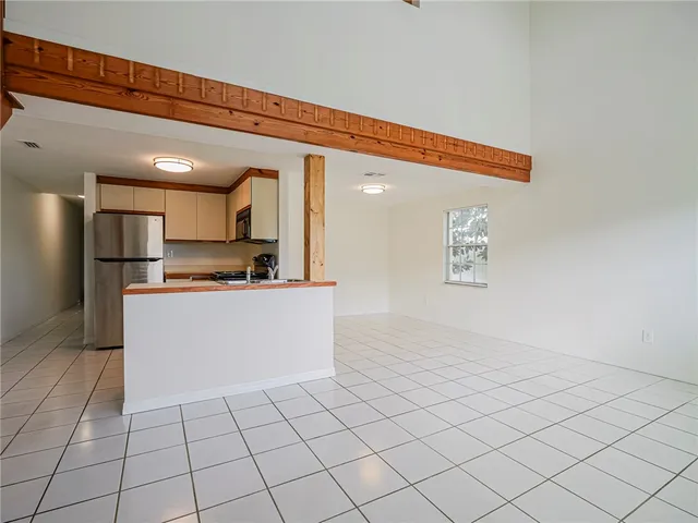 a view of kitchen with refrigerator cabinets and microwave
