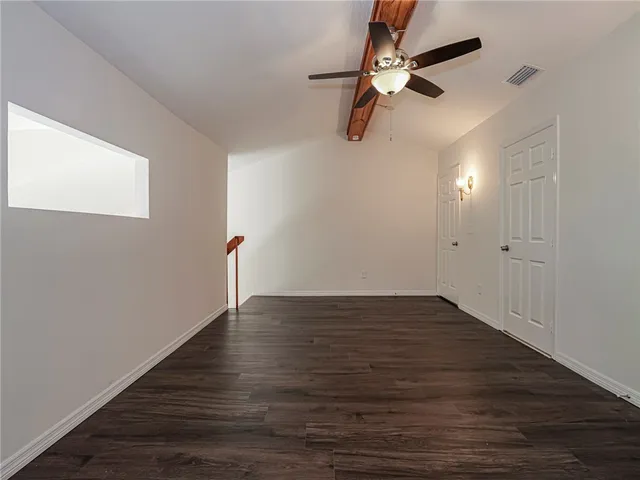 a view of empty room with wooden floor