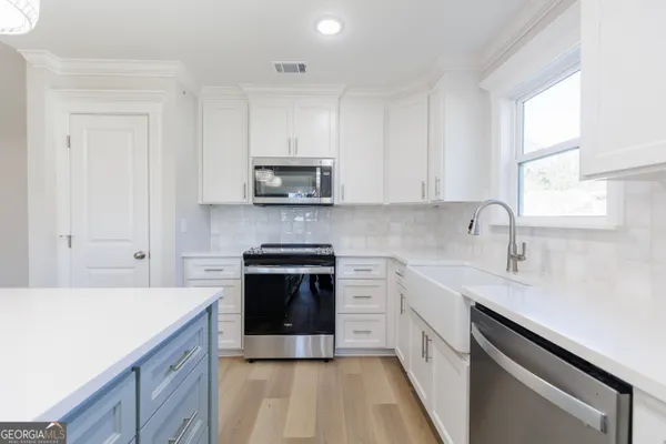 a kitchen with stainless steel appliances a sink cabinets and a stove top oven
