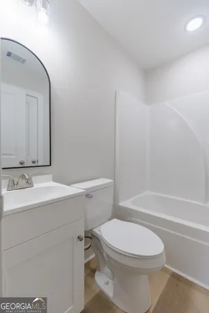 a bathroom with a sink a toilet and a mirror
