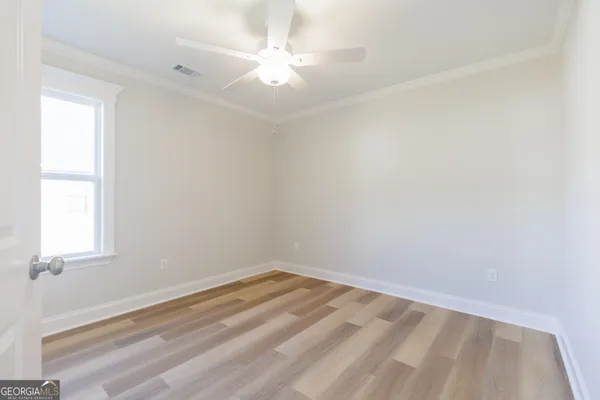 an empty room with a window and a fan