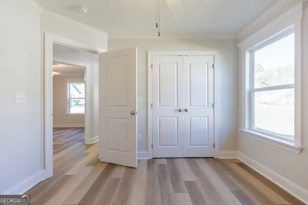 a view of a livingroom with wooden floor and a bathroom