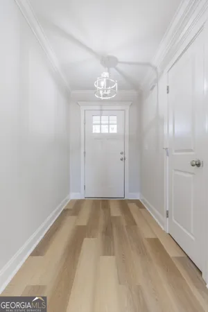 a view of an empty room with window and a kitchen