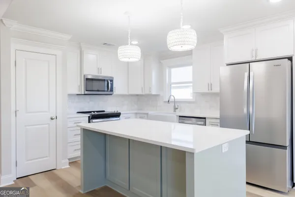 a kitchen with stainless steel appliances a refrigerator sink and microwave