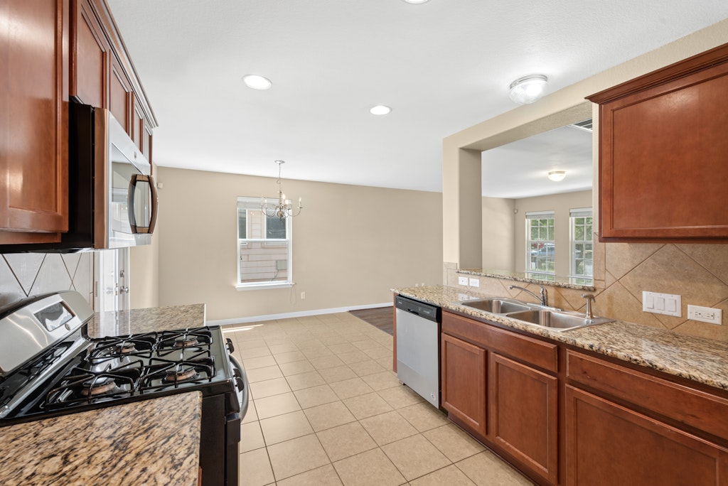 458 Nottingham Loop Kyle, TX 78640 - Photo 3 of 38 a kitchen with granite countertop a sink and a stove top oven
