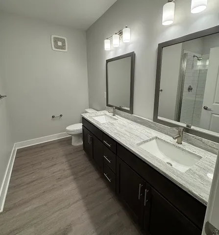 a bathroom with a granite countertop sink a mirror and shower