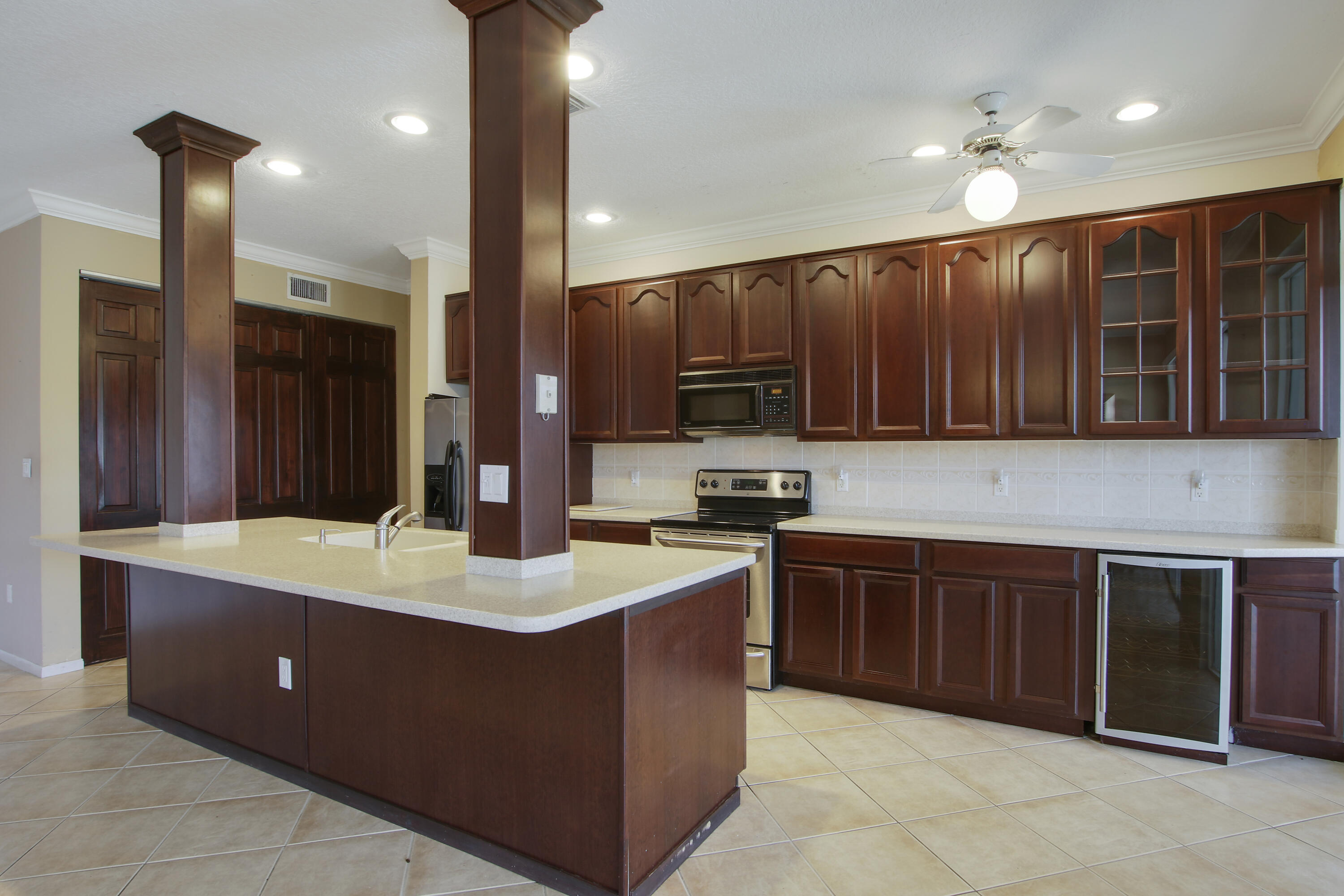 a kitchen with kitchen island granite countertop a sink counter top space cabinets and stainless steel appliances
