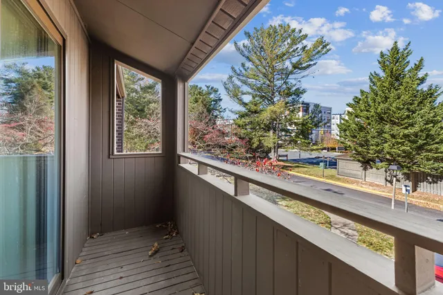 a view of a balcony with wooden floor and fence