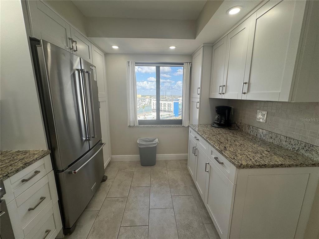 15000 Gulf Boulevard, Unit 1108 Madeira Beach, FL 33708 - Photo 11 of 20 a kitchen with stainless steel appliances granite countertop a refrigerator and a sink