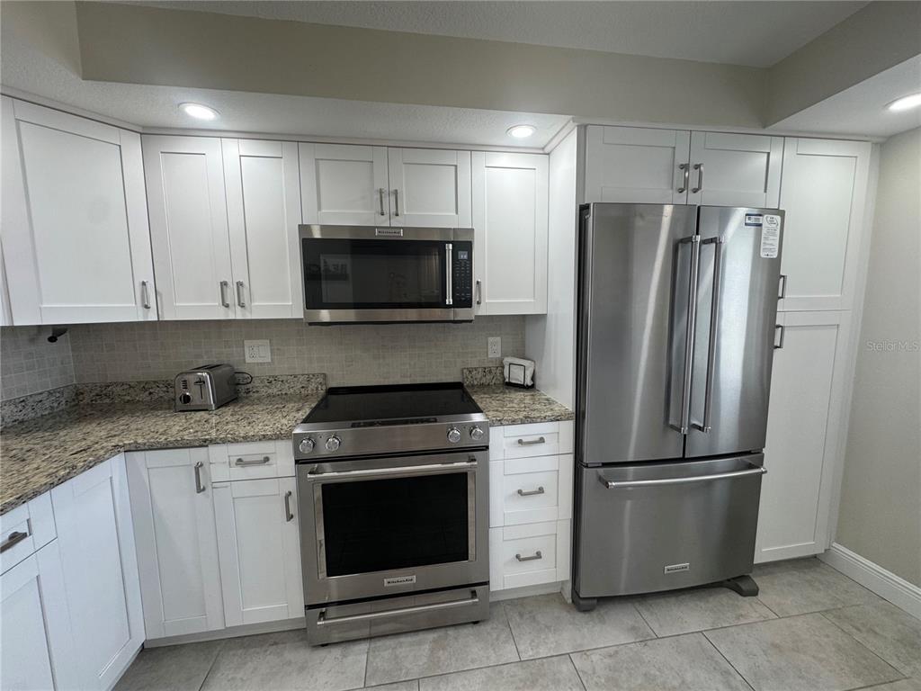 15000 Gulf Boulevard, Unit 1108 Madeira Beach, FL 33708 - Photo 10 of 20 a kitchen with a stove microwave and refrigerator