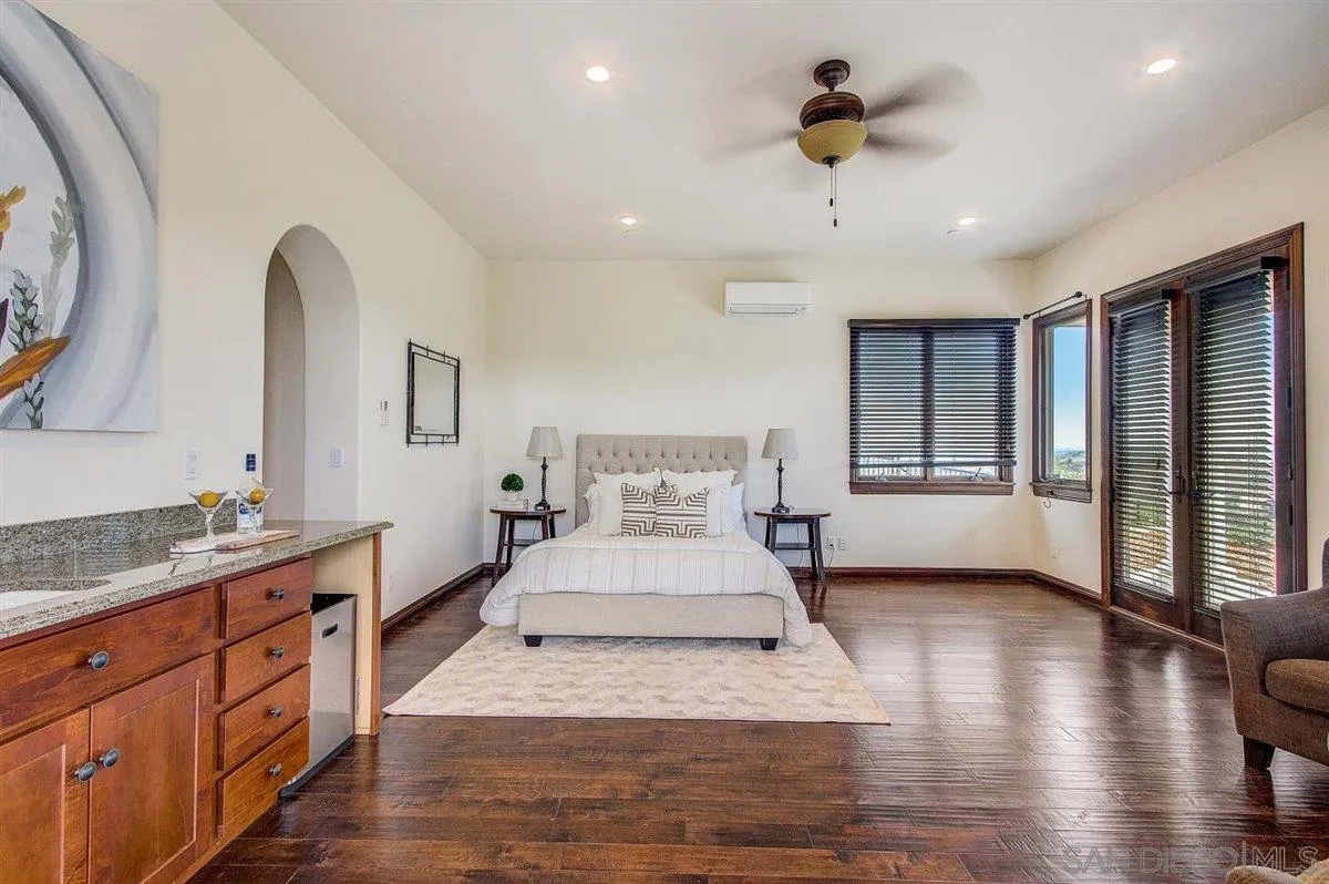 4349 Fallsbrae Road Fallbrook, CA 92028 - Photo 29 of 68 a spacious bedroom with a large bed and a chandelier