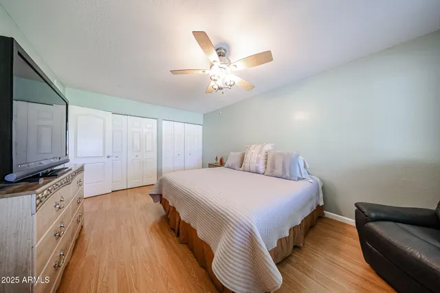 a spacious bedroom with a bed and a flat screen tv