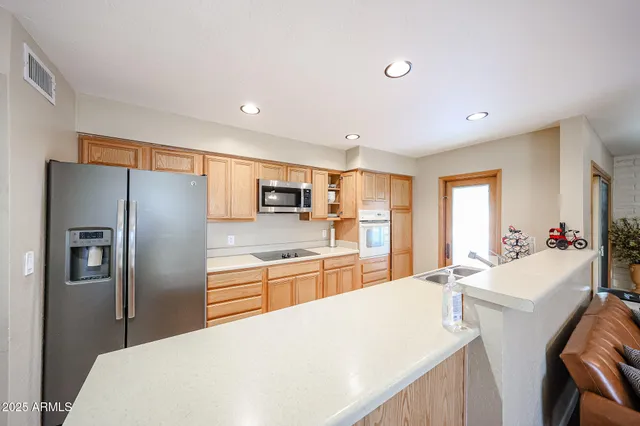a kitchen with stainless steel appliances a refrigerator sink and microwave