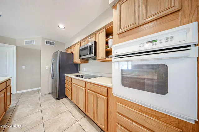 a kitchen with stainless steel appliances granite countertop a refrigerator and a stove top oven