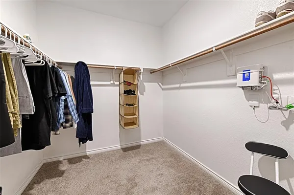 a view of walk in closet with clothes and shoes