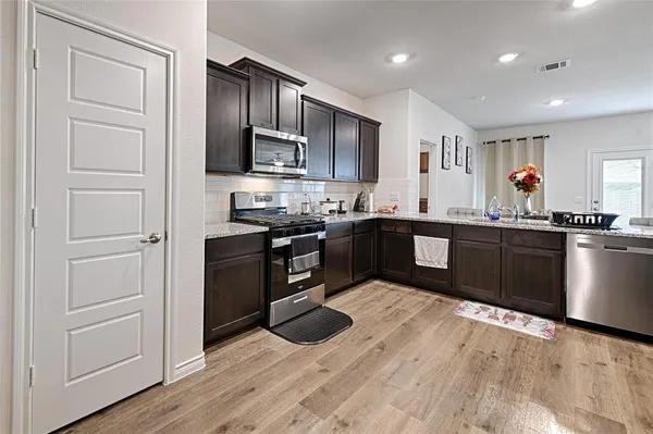 a kitchen with stainless steel appliances granite countertop a sink and cabinets