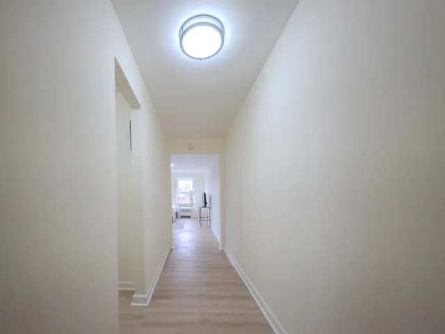a view of a hallway with wooden floor