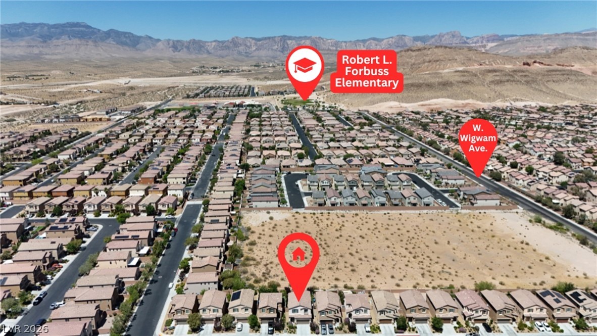 891 Earth Luster Road Las Vegas, NV 89178 - Photo 44 of 48 An aerial perspective showcases a residential neighborhood nestled against a mountainous desert landscape.