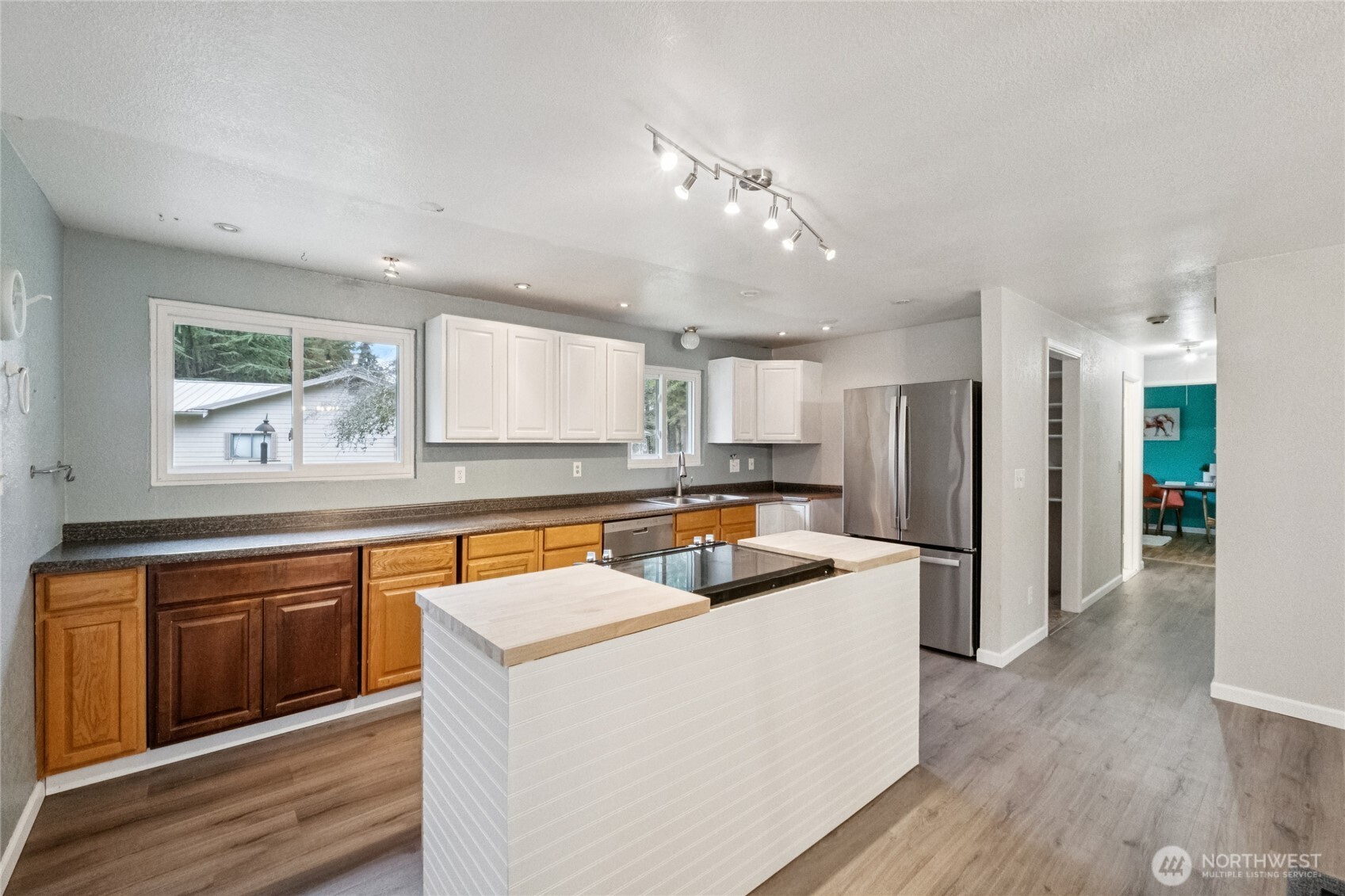 20911 West Richmond Road Bothell, WA 98021 - Photo 13 of 25 a kitchen with stainless steel appliances granite countertop a refrigerator a sink dishwasher a stove and white countertops with wooden floor