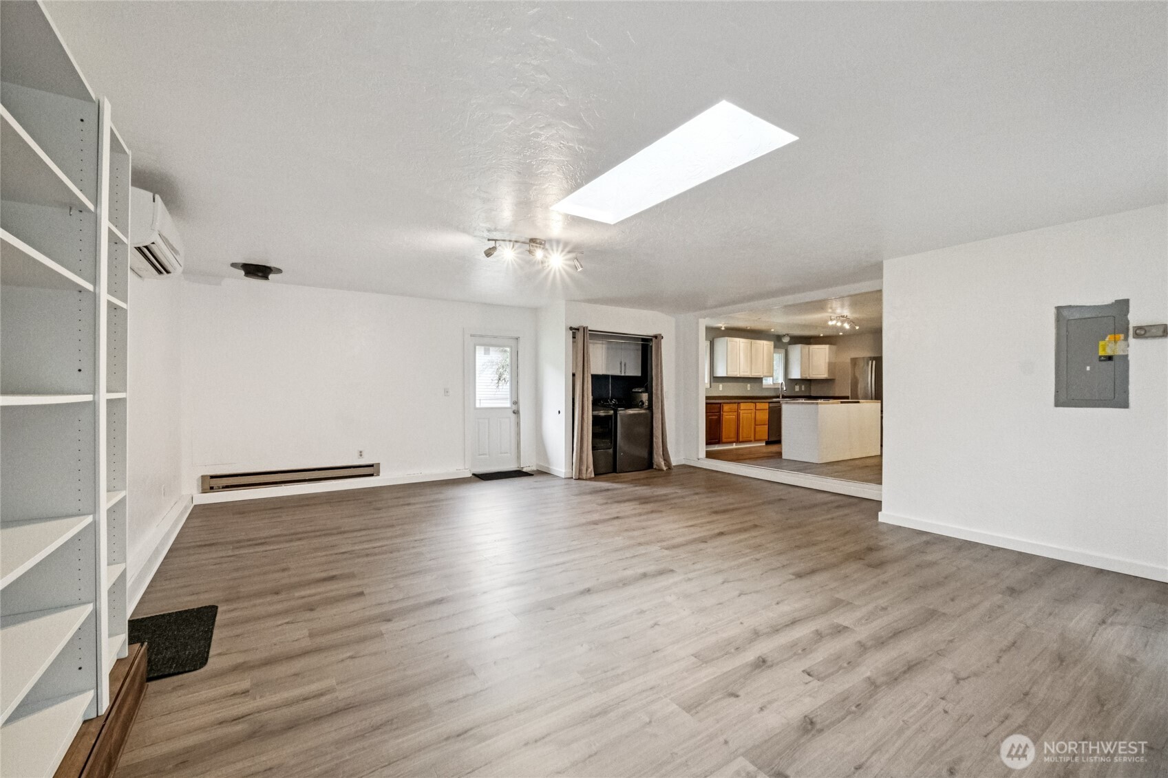 20911 West Richmond Road Bothell, WA 98021 - Photo 9 of 25 an empty room with wooden floor and kitchen view