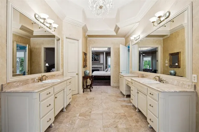 a spacious en suite bathroom with double vanity and a large mirror