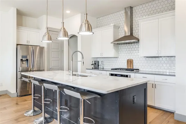 a kitchen with a sink stove top oven and refrigerator