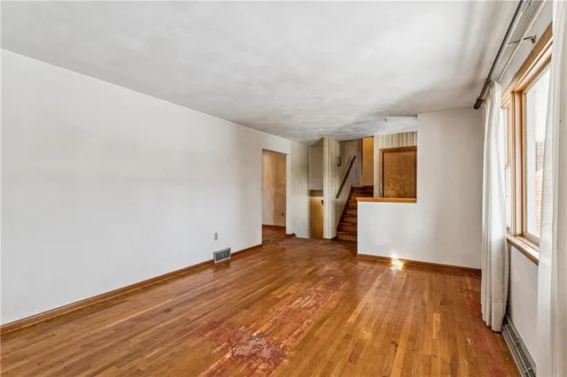 wooden floor in an empty room with a window