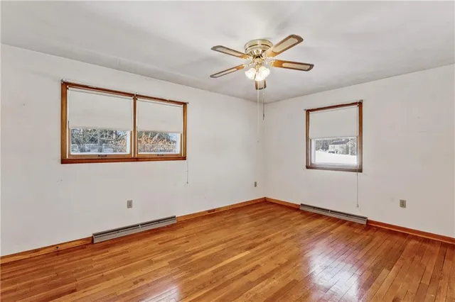 a view of empty room with wooden floor