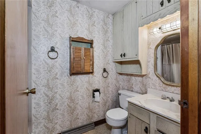 a bathroom with a toilet sink and mirror