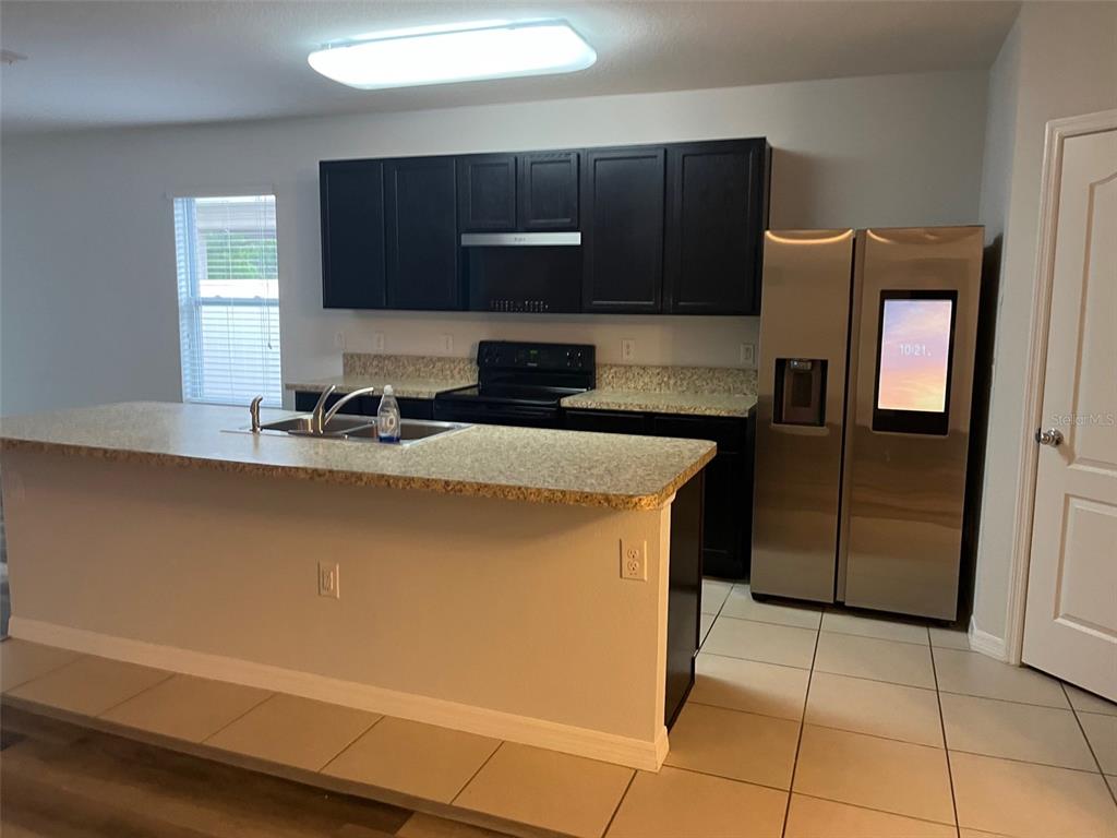 526 Safe Harbor Drive Edgewater, FL 32141 - Photo 2 of 7 a kitchen with stainless steel appliances a sink a stove a microwave a counter top and cabinets