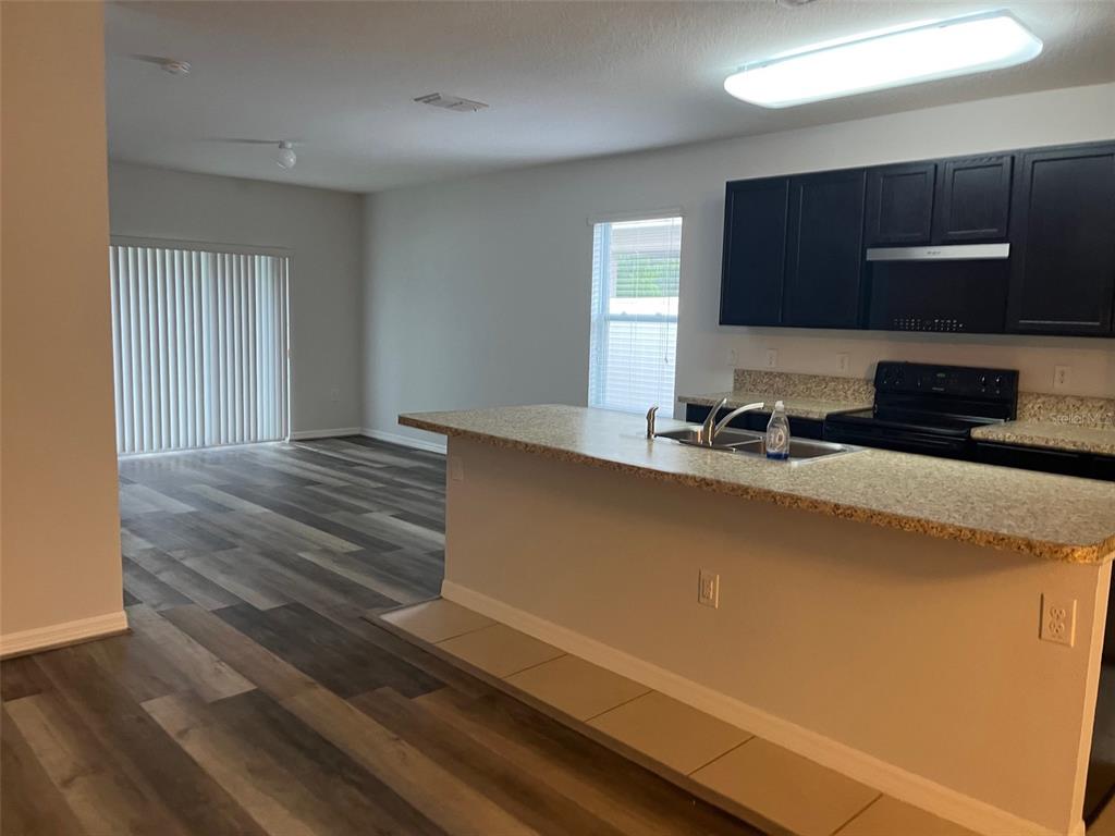 526 Safe Harbor Drive Edgewater, FL 32141 - Photo 3 of 7 a kitchen with a sink a microwave and cabinets
