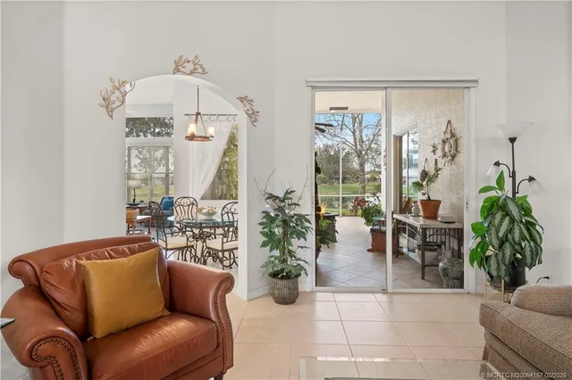 a living room with furniture a chandelier and a glass door