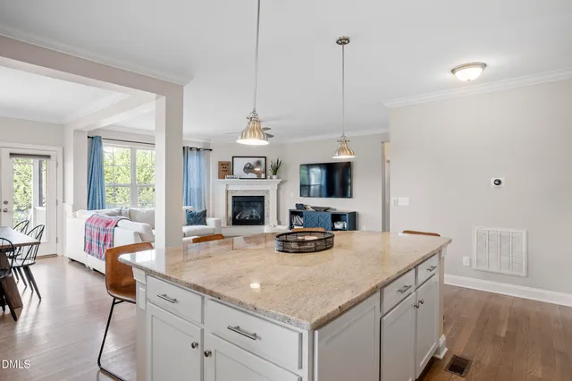 a kitchen with stainless steel appliances granite countertop a stove a sink a dining table and chairs