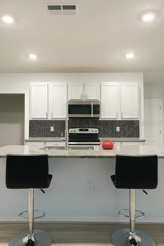 a kitchen with stainless steel appliances granite countertop a sink counter space and cabinets