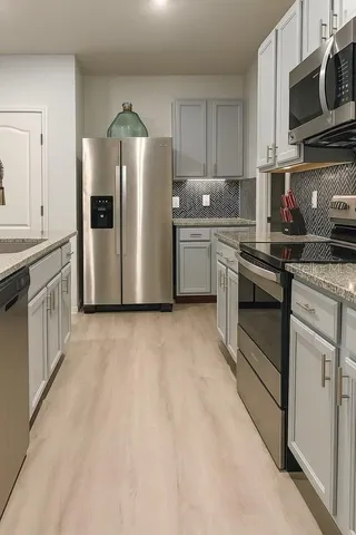 a kitchen with stainless steel appliances white cabinets and a refrigerator